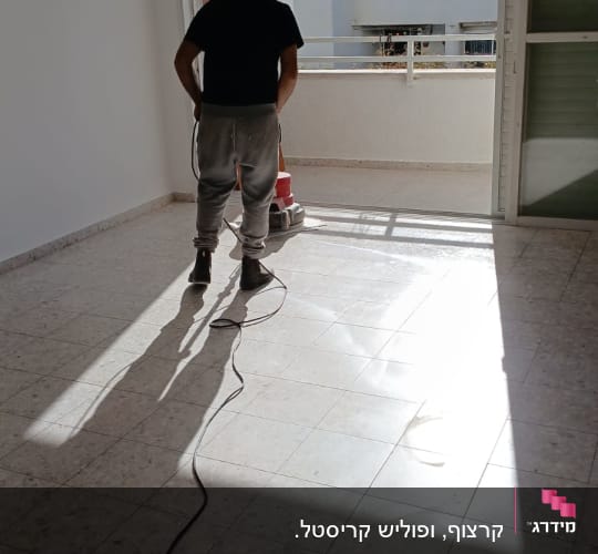 אדם מנקה רצפה עם מכונת פוליש חשמלית
